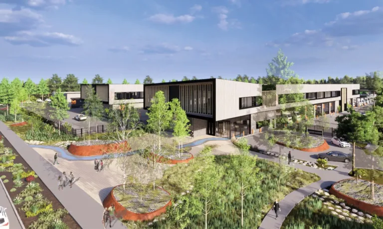 Architectural rendering of a modern two‑story commercial campus with long rectangular buildings, large windows, parking areas, and landscaped pedestrian paths with trees and raised planters under a blue sky.