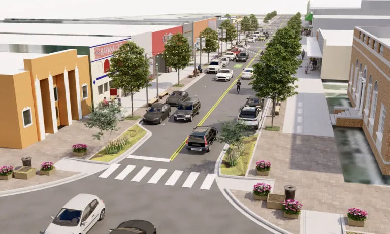3D rendering of a redesigned urban main street with two travel lanes and parallel parking, tree‑lined wide sidewalks with benches and planters, a zebra crosswalk, pedestrians by storefronts, and bicycle sharrow markings.